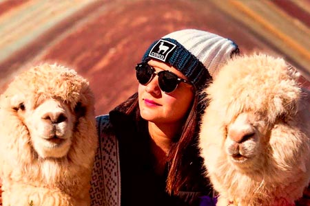 A selfie with two llamas on the rainbow mountain