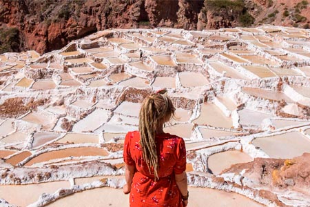 Tourist in front of the salt mines of the Maras Moray route in the Sacred Valley of the Incas
