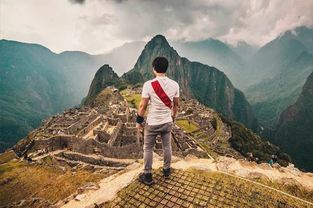 Tourist with a polo from the selection of Peru in the citadel of Machu Picchu