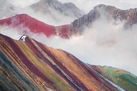 The spectacular rainbow mountain next to the clouds in the Andes