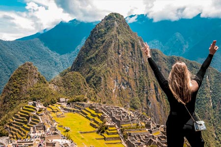 Tourists raising their hands in front of Machu Picchu