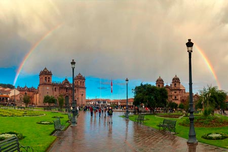Cusco main square with a rainbow in the sky