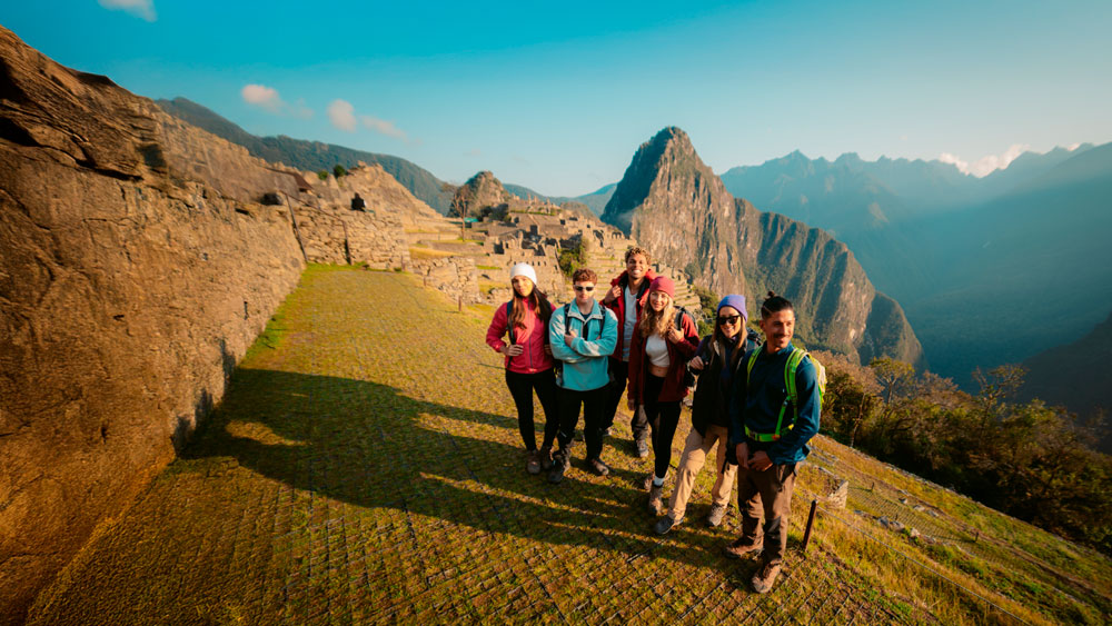 Tourists posing for a photo with Machu Picchu's background.
