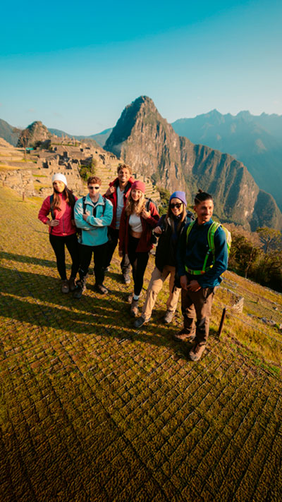 Tourists posing for a photo with Machu Picchu's background.