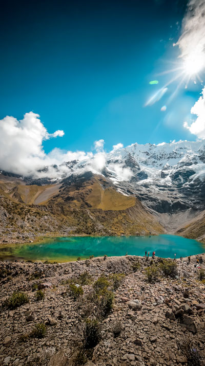 Man reflecting and admiring the amazing Humantay lake under the Humantay Glacier (Recharging energies in the mountains of Peru)