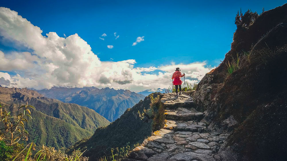 Woman hiking the incredible ancient Inca Trail to Machu Picchu near the cliff