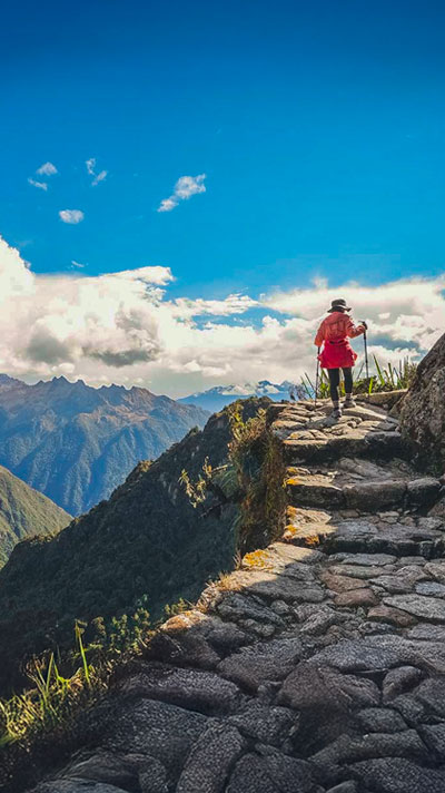 Woman hiking the incredible ancient Inca Trail to Machu Picchu near the cliff