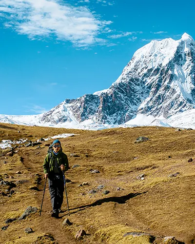 Tourist walking next to the impressive Ausangate mountain