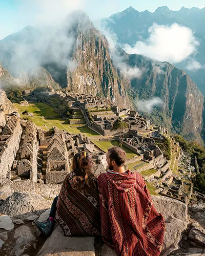 A couple of travelers impressed with the wonderful view of Machu Picchu