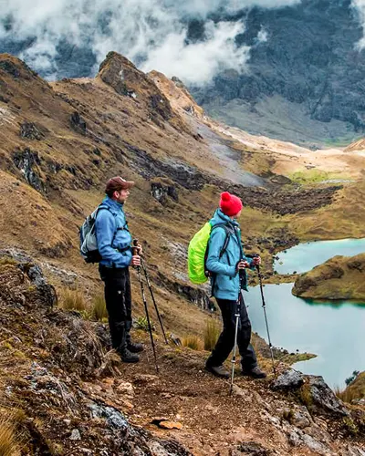 Two tourists walking through the wonderful lakes and mountains of the Lares route