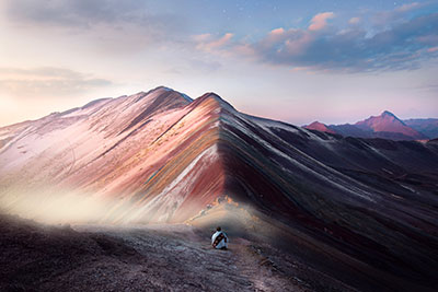 Tourist sitting in front of the Rainbow Mountain