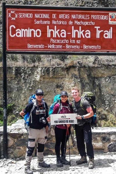 Small group of happy visitors in entrance of the Inka Trail Classic, KM 82