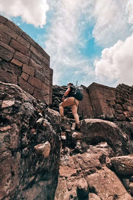 Tourist exploring archaeological site of Waqrapukara