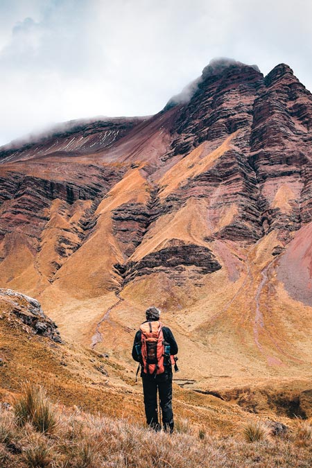 Tourist with his hiking backpack in the vastness of the mountains