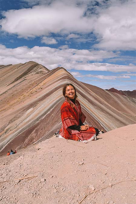Tourist sitting in front of the mountain of colors