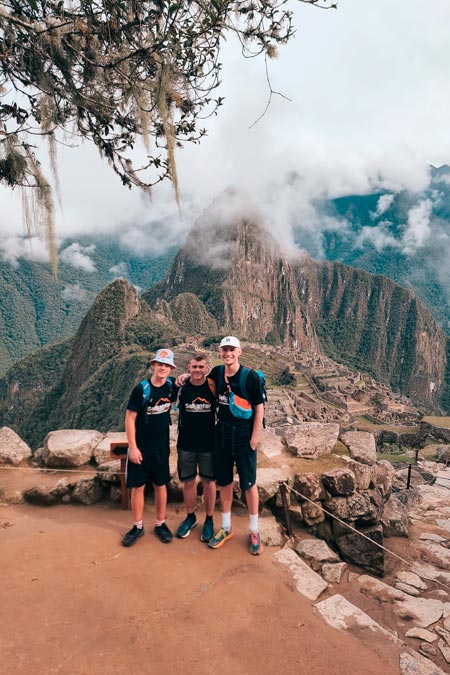 Three tourists with black pole in Machu Picchu