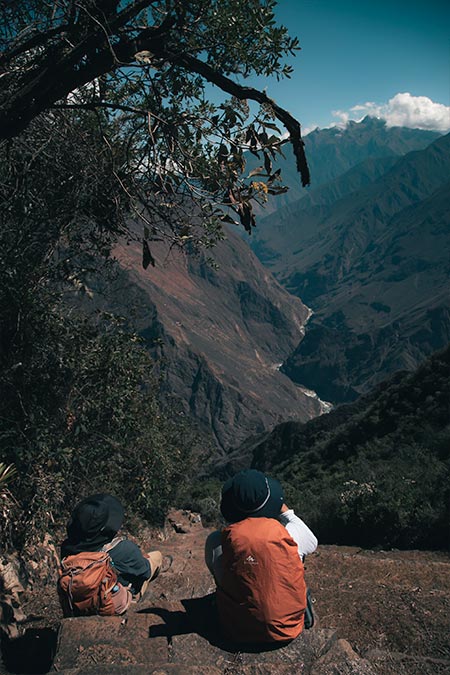 Two tourists viewing the grand canyon from Choquequirao